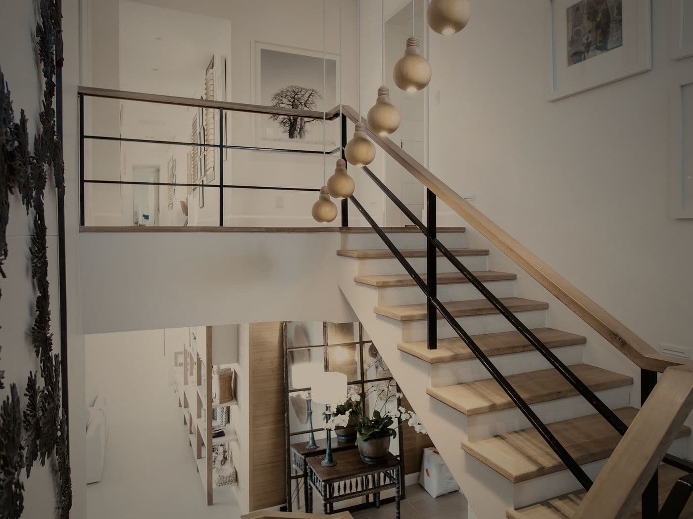 A cantilevered timber and steel staircase in a Finlay Realty home, lit by a clerestory window above.