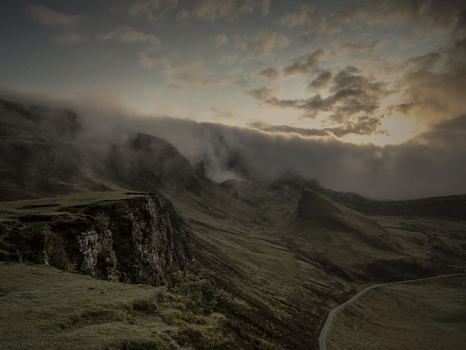 The approach road to Finlay Terraces winding through open country towards the hills.
